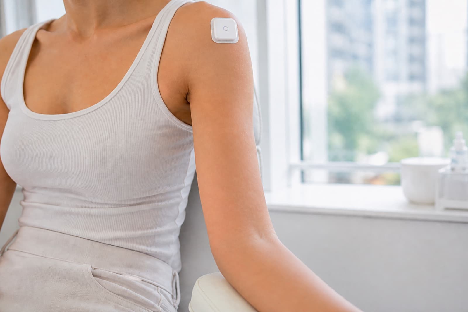 A square blood-collection device adhered to a person's shoulder