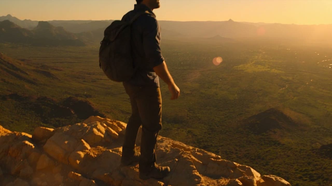Hiker climbing a rocky slope in golden light