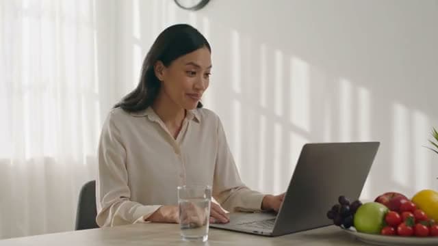 A person laughing during a laptop video call